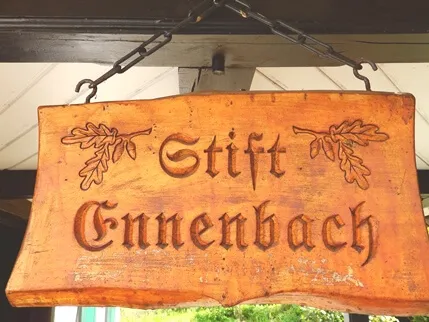 Rustikales Eingangsschild des Ferienhauses aus Holz mit gefrästen Eichenblättern